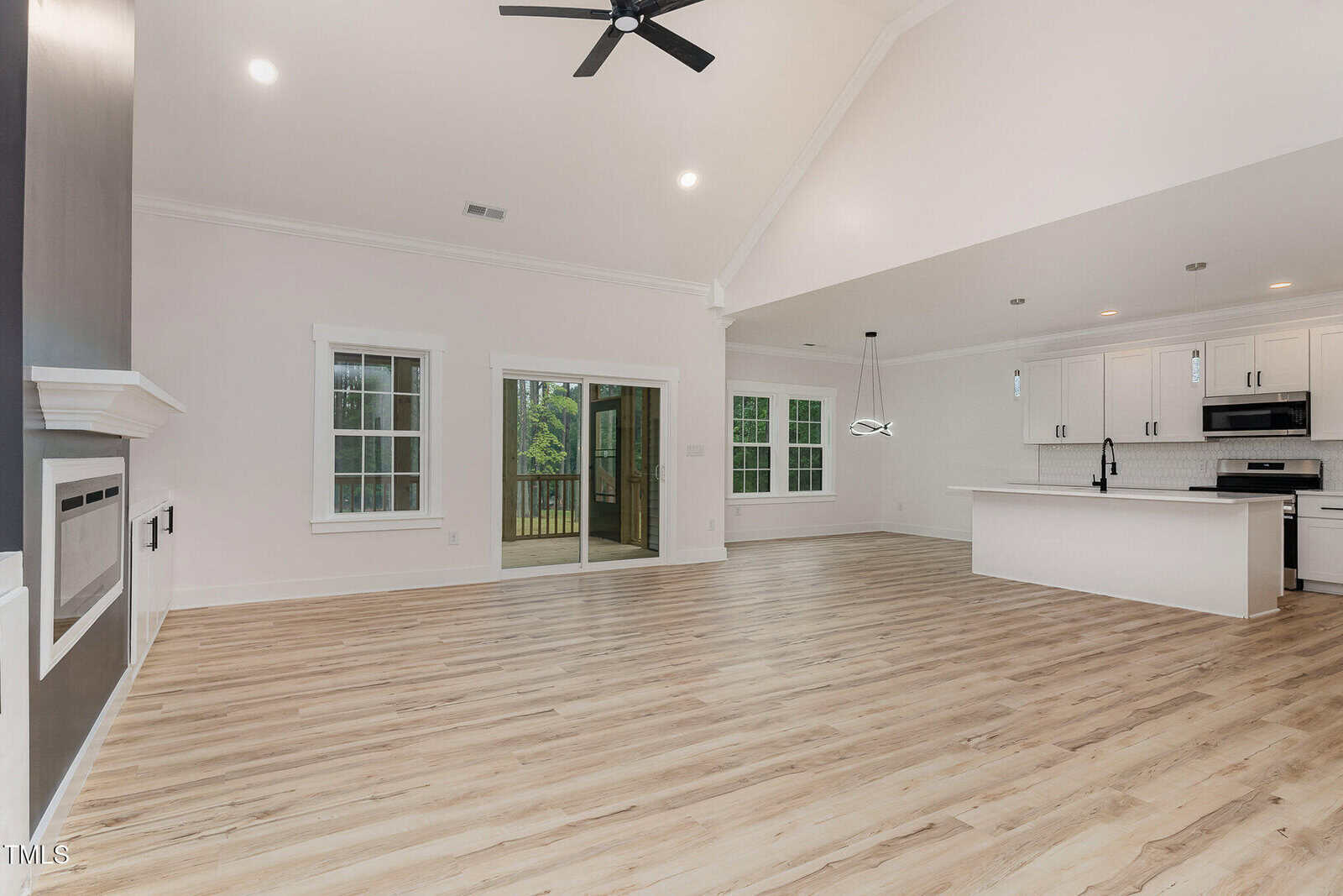 A large room with a wood floor and ceiling fan.