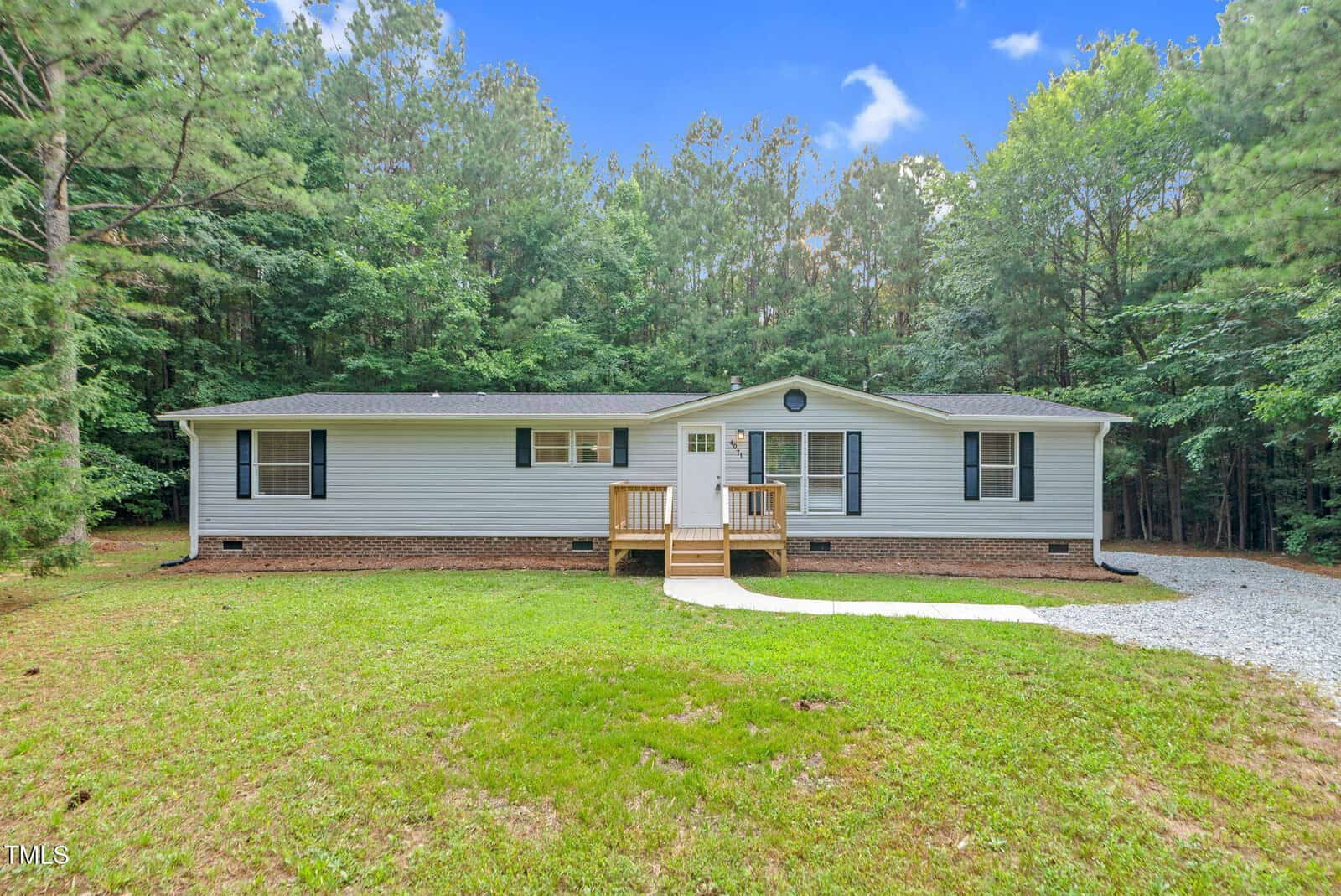 A single-story gray house with white trim and a dark roof sits at 4071 Kimball Road in Oxford, featuring a small wooden porch, brick foundation, and walkway to the front door. A gravel driveway is on the right.