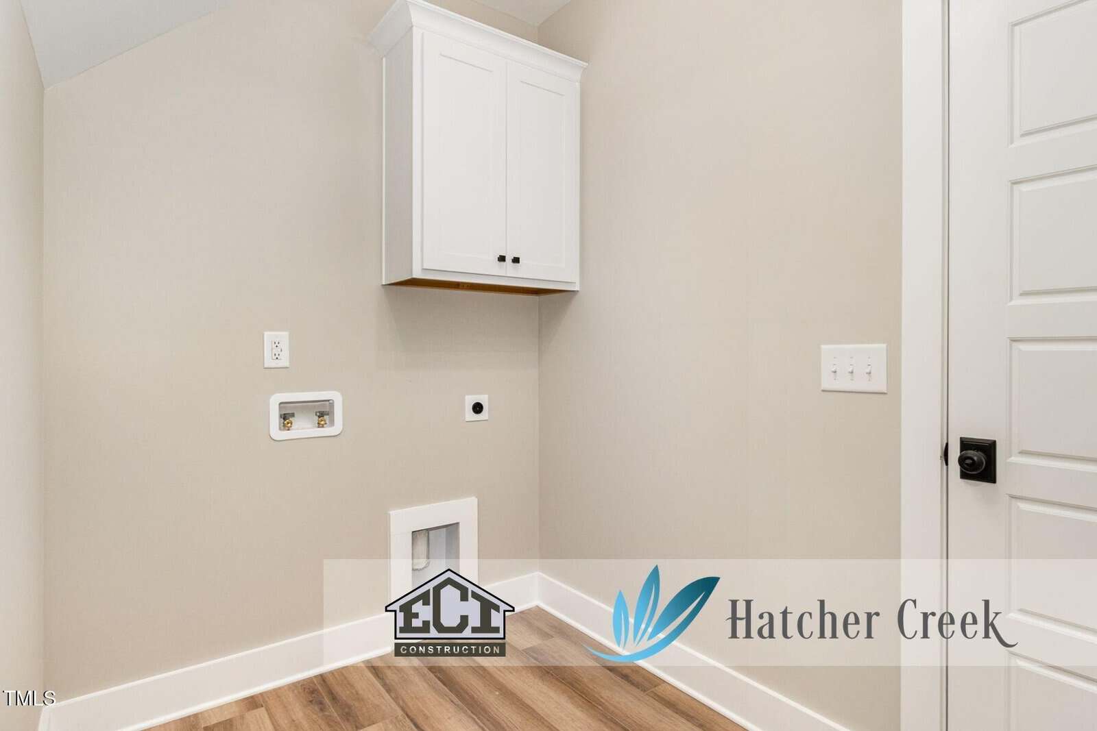 Laundry room with light beige walls, wood floors, white cabinet, washer and dryer hookups, electrical outlets, and a white door. Hatcher Creek and ECI Construction logos are visible on the image.