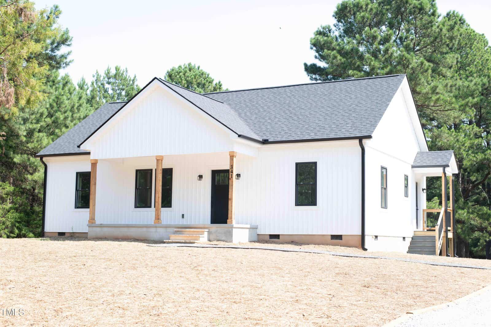 A single-story white house with black trim at 341 Rev Henderson Road, Henderson, features a gabled roof, wooden porch columns, and a small entry porch. The yard is mostly bare soil with green trees in the background.