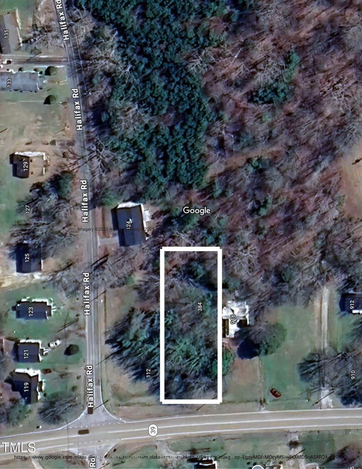 Aerial view of a wooded lot outlined in white near Halifax Road. Surrounding area includes scattered houses, roads, and patches of forest and open grass. The outlined area is mostly covered by trees.