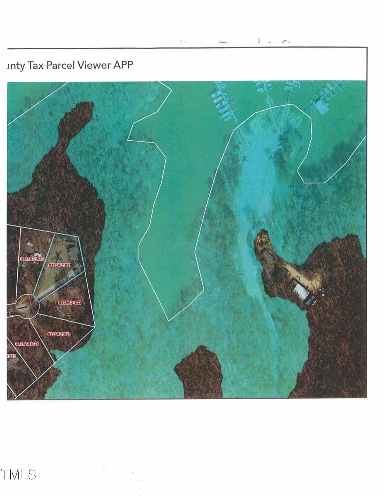 Aerial map showing a coastal area with property parcel boundaries outlined, a group of labeled plots on the left, water in the center and right, and docks or structures visible near the shoreline on the right.