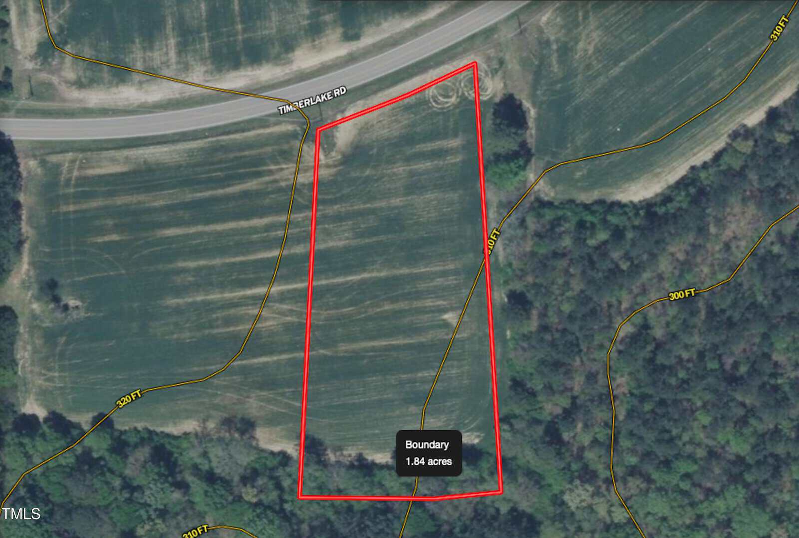 Aerial view of a 1.84-acre triangular plot outlined in red, bordered by Timberlake Road at the top and surrounded by fields and wooded areas. Yellow contour lines indicate distance in feet from the boundary.