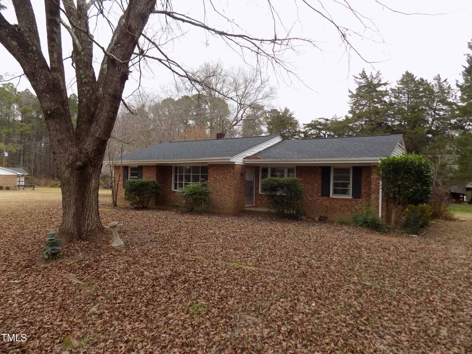 A brick house on 994 Alert Road with a tree in the back, nestled in charming Warrenton.