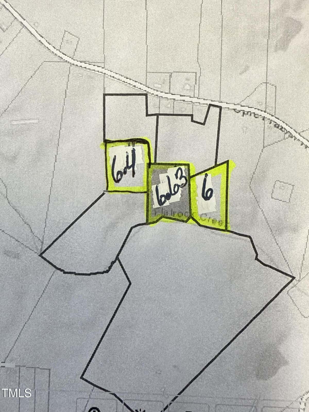 A black and white map shows three adjacent land parcels outlined in yellow and labeled by hand as "Lot 4," "Lot 3," and "Lot 6." Roads and surrounding property lines are faintly visible in the background.