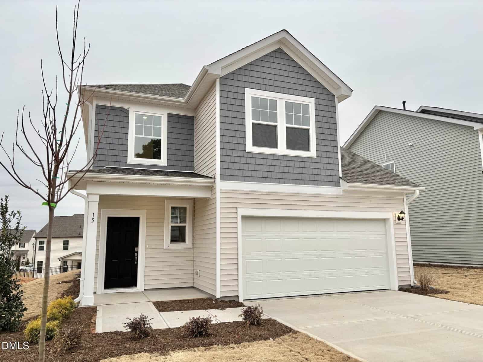 This modern two-story house at 15 Gerrad Street in Franklinton features gray siding, white trim, a double garage, and minimal landscaping with a small tree and brown grass beneath an overcast sky.