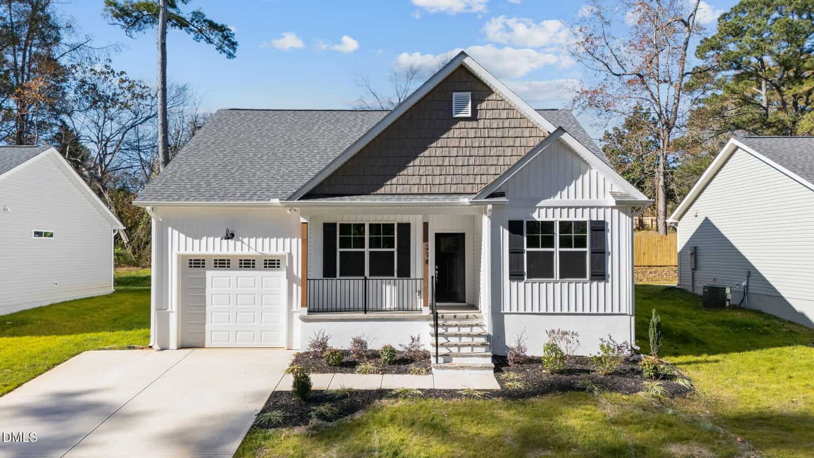 A small, modern single-story house at 216 E College Street in Franklinton features a gable roof, attached one-car garage, front porch with steps, and landscaped yard. The light-colored exterior has brown accents, surrounded by green grass and trees.