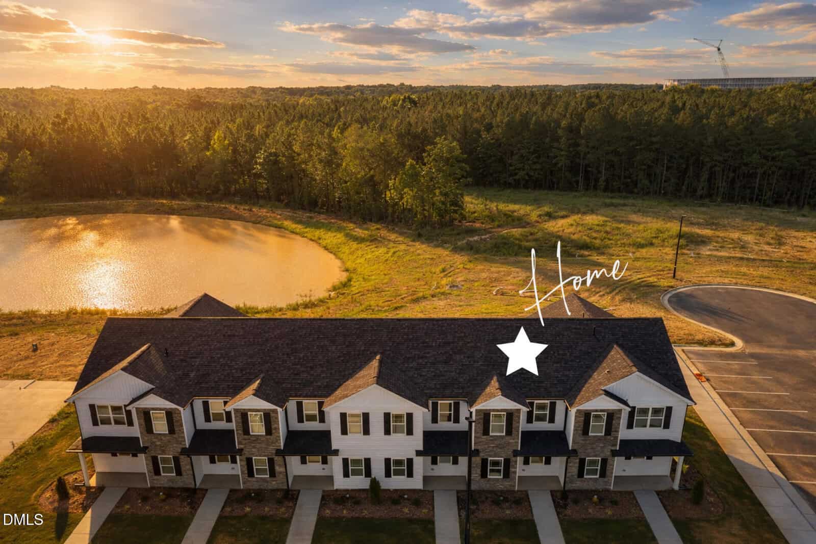 Aerial view of a row of Oxford townhomes next to a pond and wooded area at sunset; a white star and the word "Home" highlight 1105 Brookrun Drive above one unit.