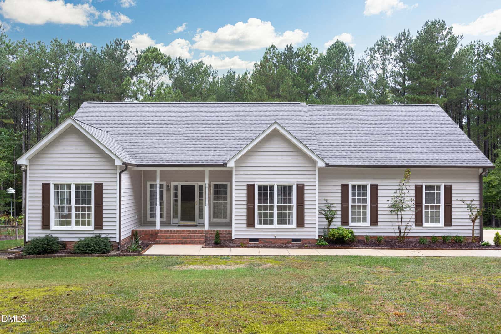 A single-story house at 3653 Range Road in Stem features light gray siding, white trim, a gray shingle roof, several front-facing windows with dark shutters, a small brick front porch, and is surrounded by grass and trees.
