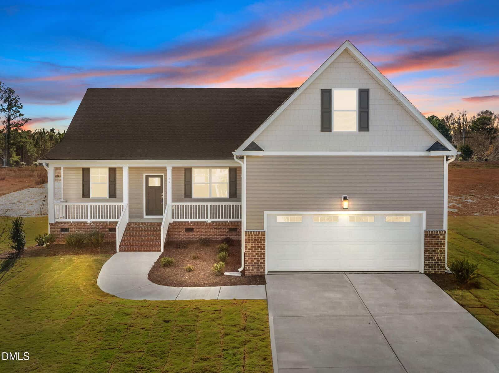 A modern single-story house with a front porch, double garage, and gabled roof, set against a colorful sunset sky with neatly manicured lawn and driveway.
