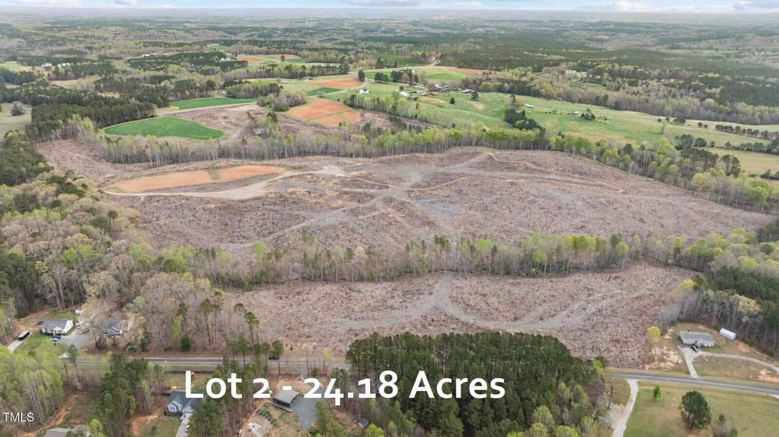 Aerial view of a large, partially cleared rural lot on 2706 Flat Rock Road, Franklinton, surrounded by trees, with scattered homes and farmland in the distance. Text on image reads: “Lot 2 – 24.18 Acres.”.