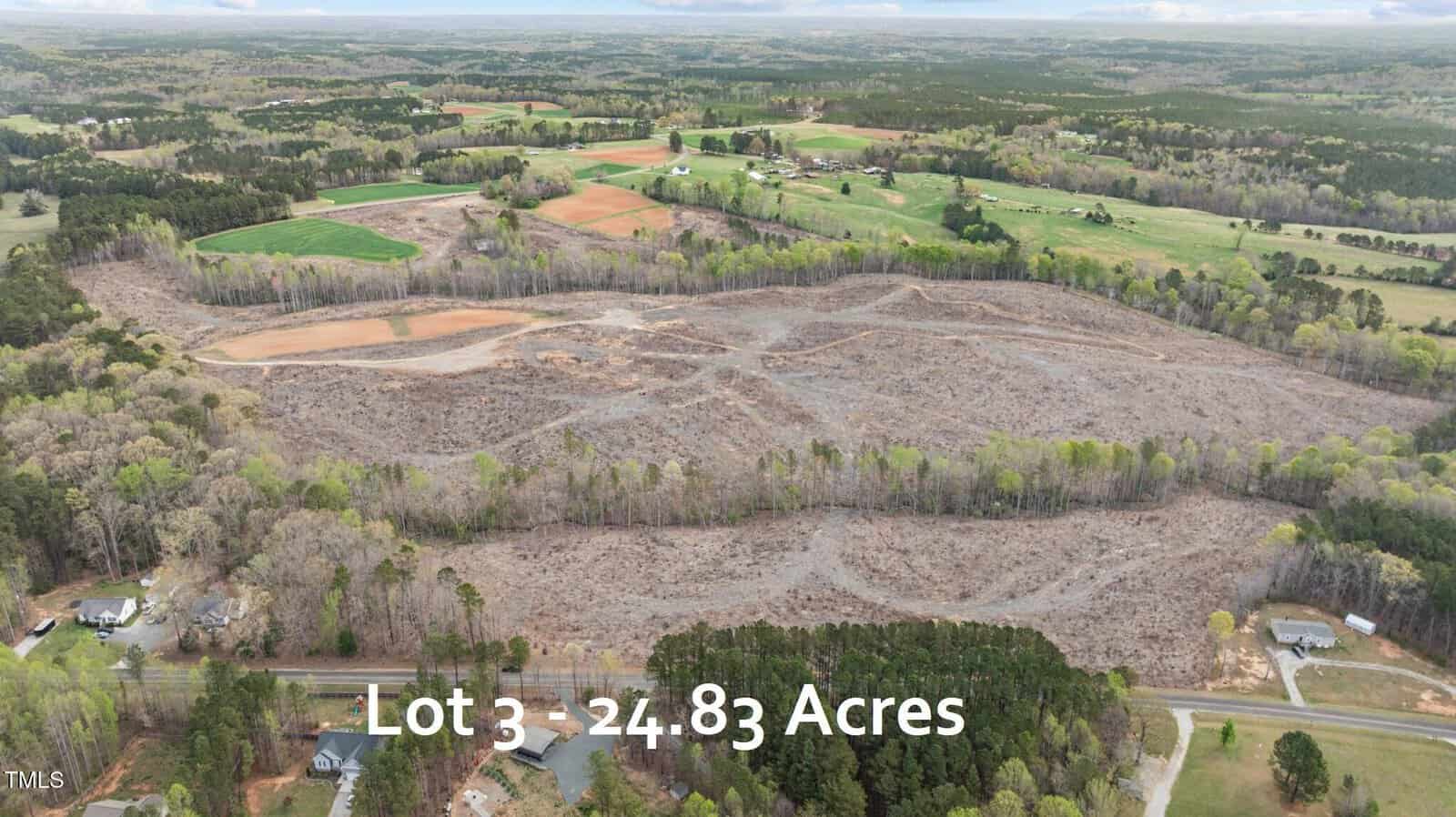 Aerial view of a large, mostly cleared plot of land surrounded by trees and scattered houses, labeled “Lot 3 - 24.83 Acres,” with fields and forested areas in the background near Franklinton, located at 2718 Flat Rock Road.