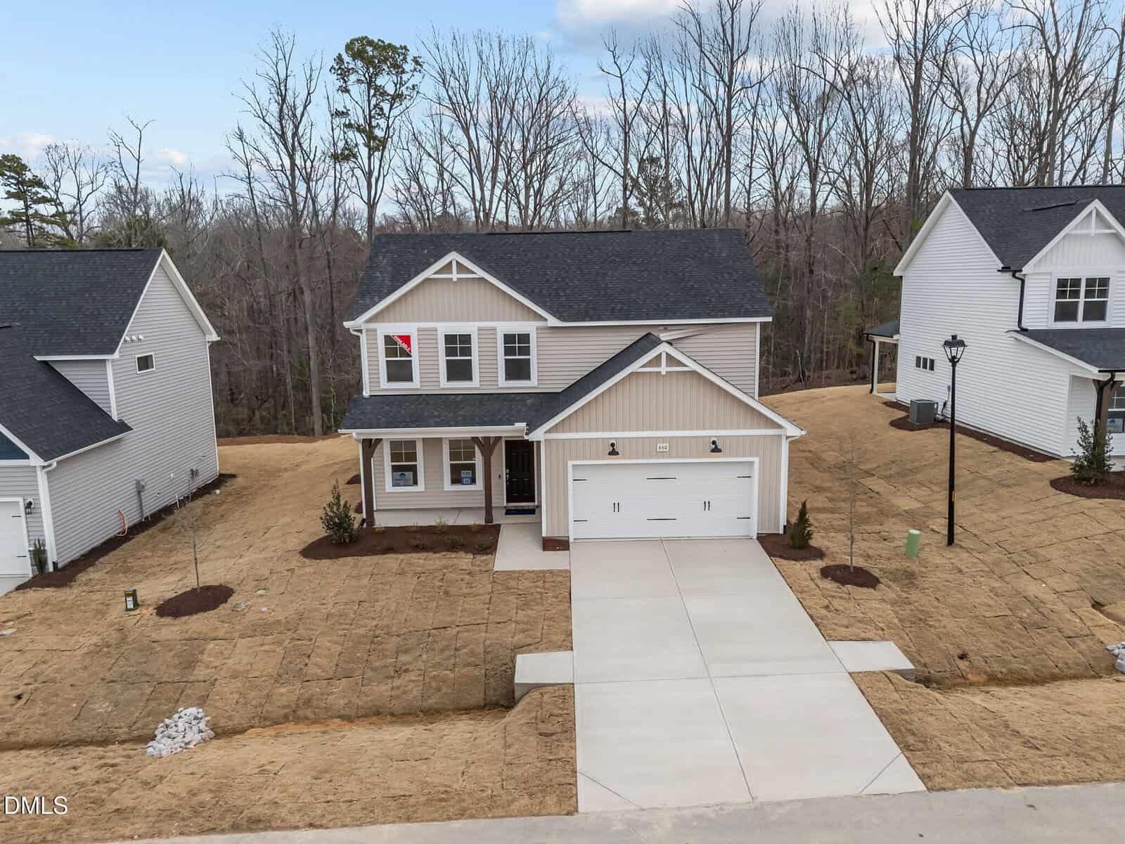 Two-story house with landscaped driveway and trees
