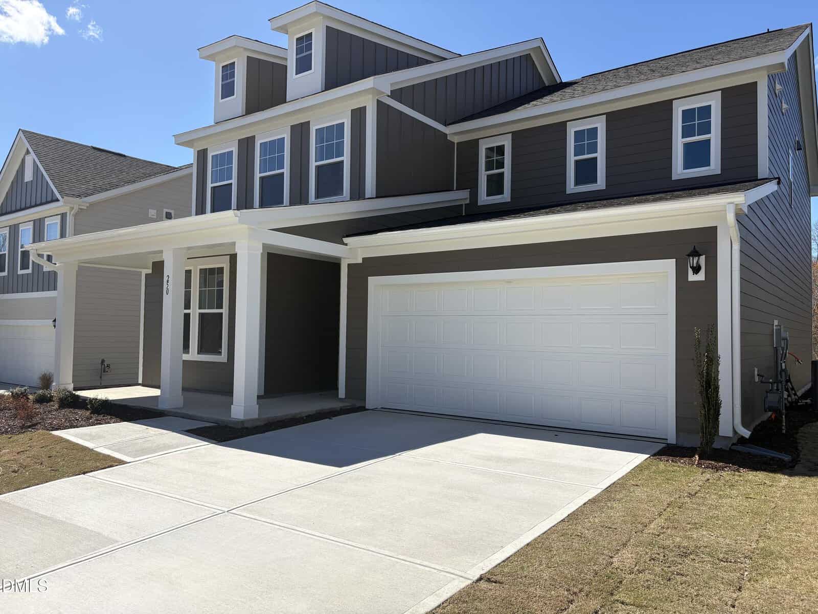 A modern two-story house at 250 Sugar Pine Drive in Franklinton, featuring gray siding, white trim, a large white double garage door, a covered front porch, multiple front-facing windows, and a neatly maintained lawn and driveway.