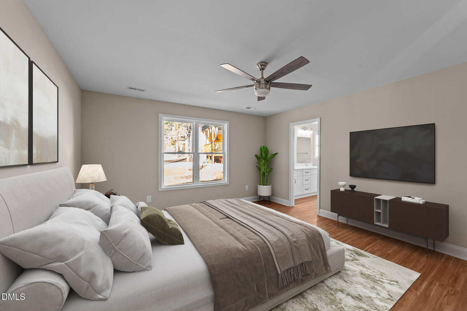A modern bedroom with a large bed, neutral bedding, a bedside lamp, wall art, a ceiling fan, a TV on a console, wood floors, a green plant, and two windows showing autumn trees outside.