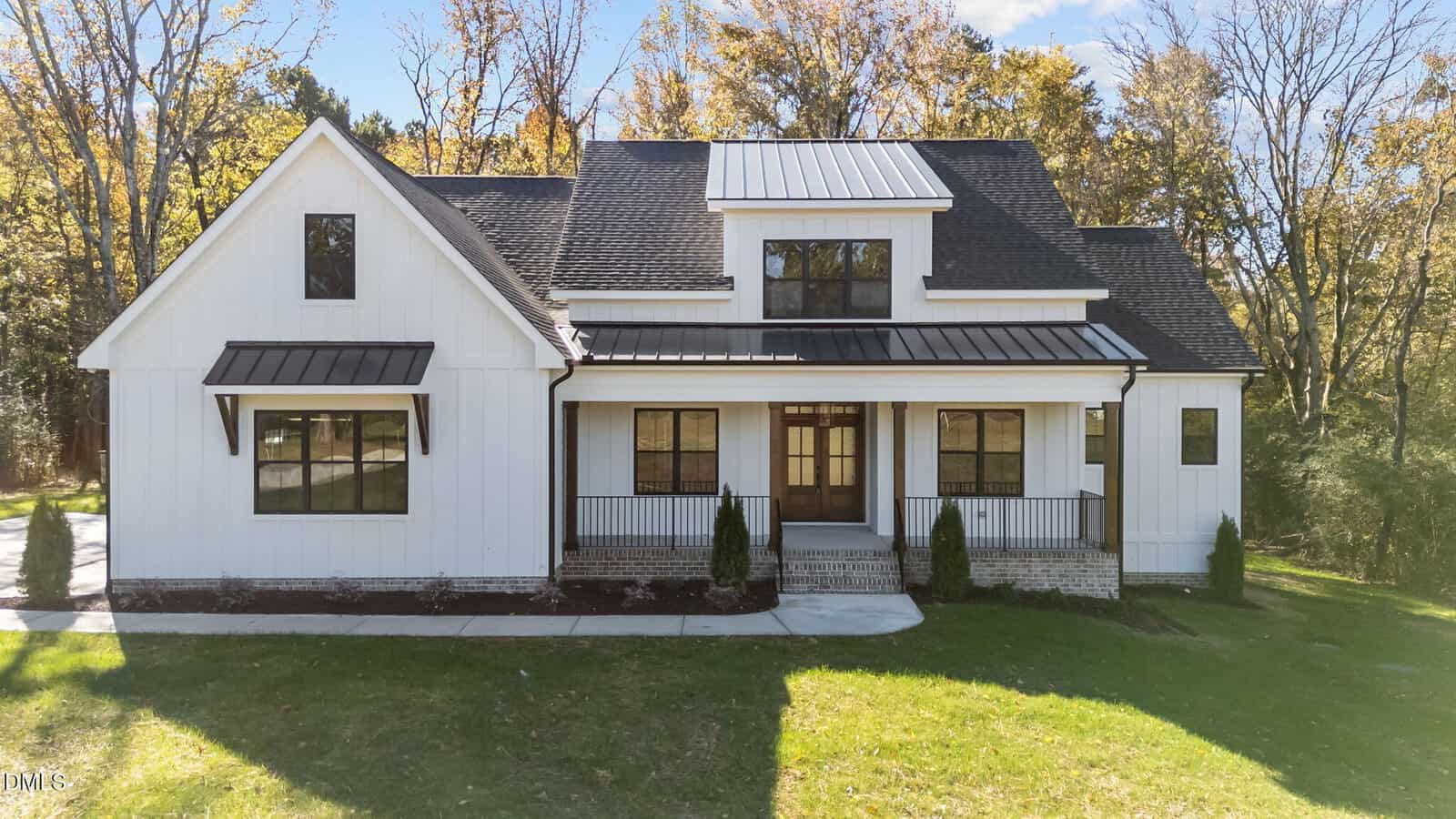A modern white house with black trim at 1100 Waterstone Lane, Henderson, features a covered front porch, large windows, and is surrounded by grass and trees under a clear sky.