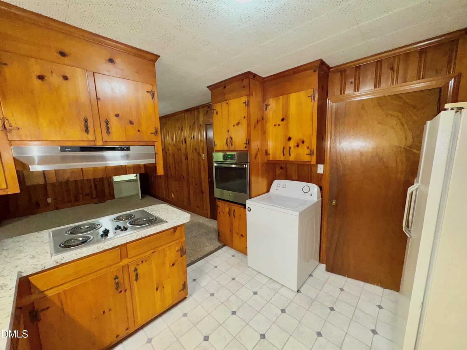 A kitchen with wood cabinets and appliances.