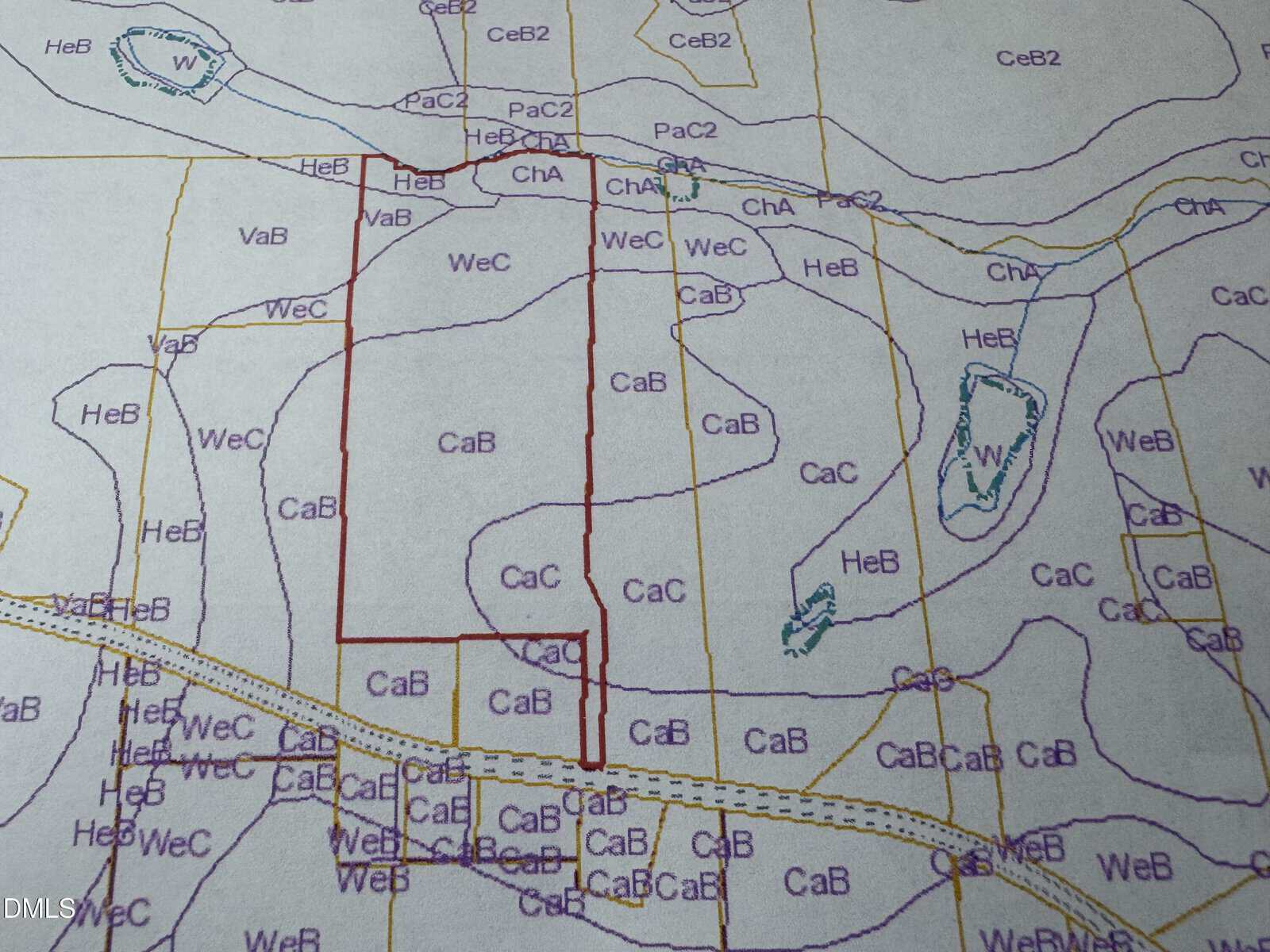 A map displays outlined land parcels with various soil type codes such as CaB, WeC, and HeB. Contour lines and water features are also marked, and one area is highlighted with a red boundary.