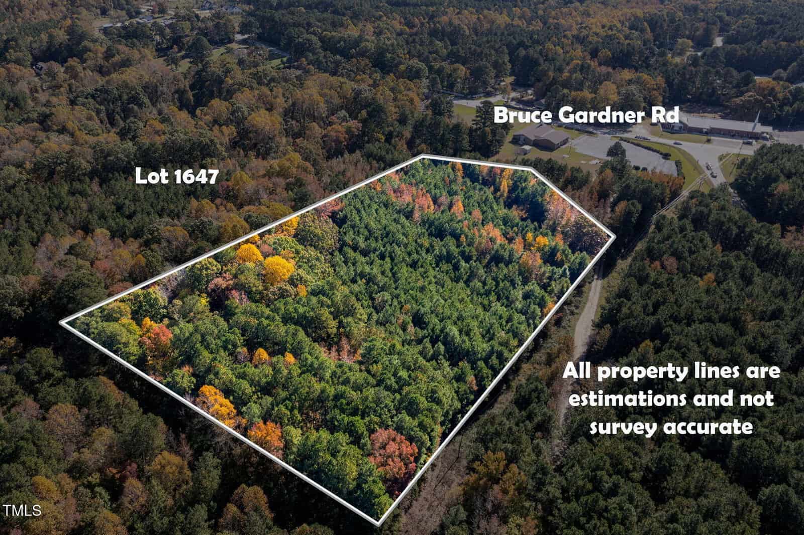 Aerial view of a wooded lot at 0 Bruce Garner Road, Creedmoor, outlined in white and labeled Lot 1647. Property lines shown are estimated, not survey accurate. Trees display a mix of green and autumn colors.