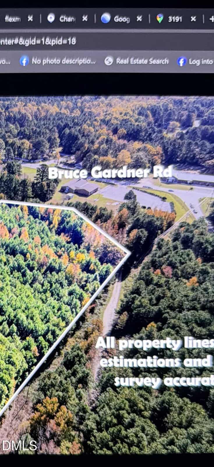 An aerial view of a wooded area with labeled property lines. Text on the image reads "Bruce Gardiner Rd" and "All property lines are estimations and not survey accurate." A road and parking lot are visible.