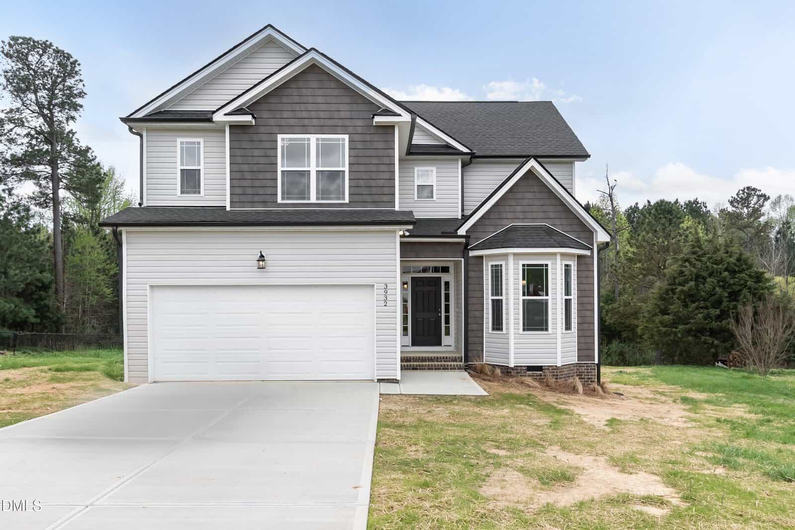 Modern two-story suburban home at 590 Long View Drive, Youngsville, featuring gray siding, dark shingles, an attached two-car garage, and a small front porch on a partly grassy lot with trees in the background.