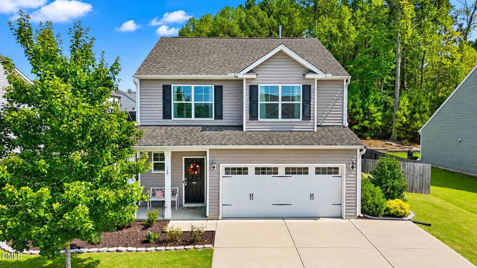 Two-story suburban house with gray siding, white trim, and two-car garage located at 190 Kimberling Drive in Franklinton. Well-maintained lawn and landscaping, large tree in the front yard, and a wooden fence in the backyard. Bright, sunny day with blue sky and green trees.
