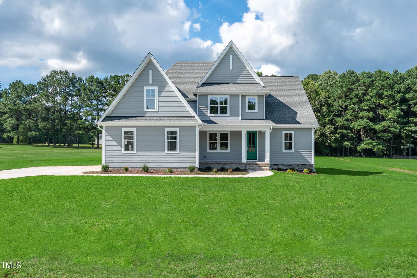 A two-story gray house with white trim sits on a large, well-manicured lawn at 105 Viola Lane, Franklinton. The home features multiple gables, a covered front porch, and is surrounded by trees under a partly cloudy sky.