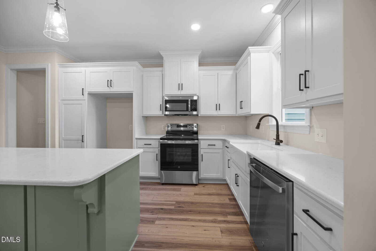 A kitchen with white cabinets and a black and silver stove.