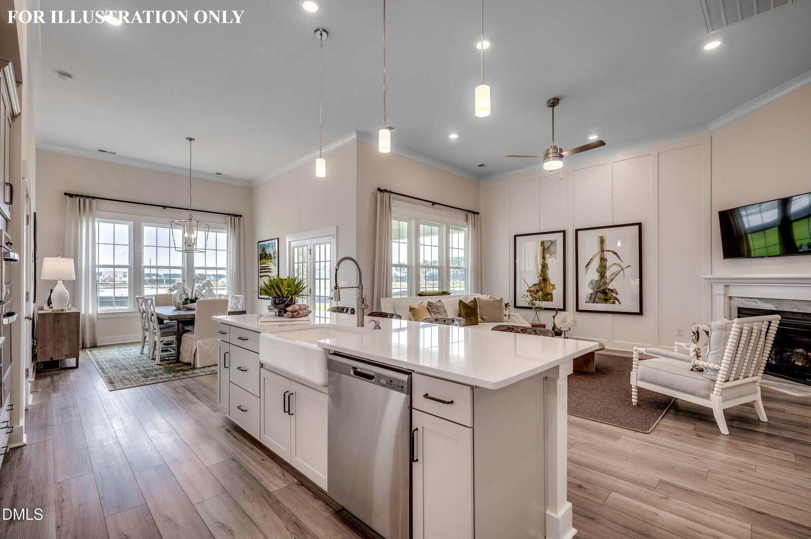 Modern open-concept kitchen and living area with white cabinets, island with sink, pendant lights, wood floors, dining table, large windows, and neutral décor. Fireplace and TV are on the right.