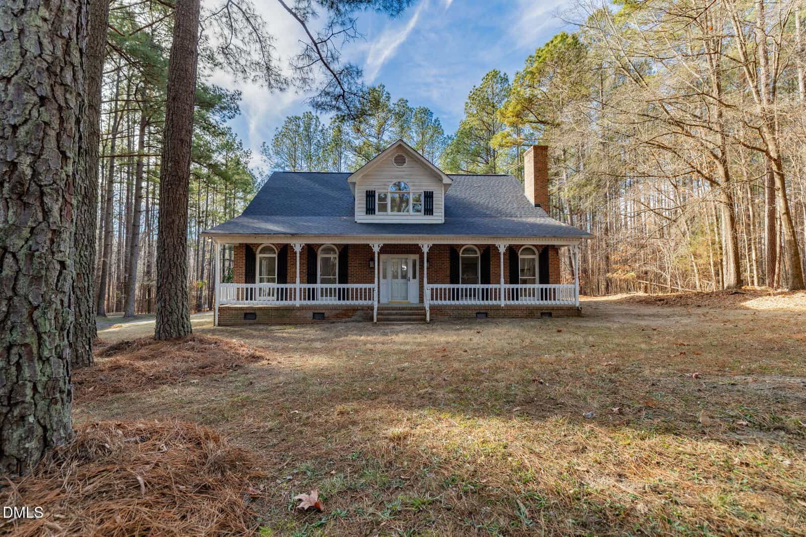 A two-story house with a covered front porch and dormer windows sits at 892 Franklin Lane in Henderson, surrounded by tall trees and a grassy yard, under a partly cloudy sky.