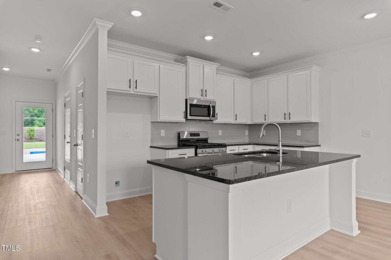 A kitchen with a black counter top.