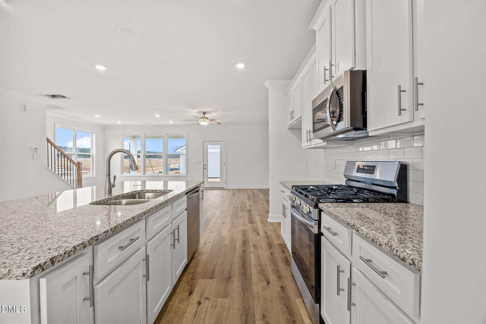 A kitchen with white cabinets and granite counter tops.