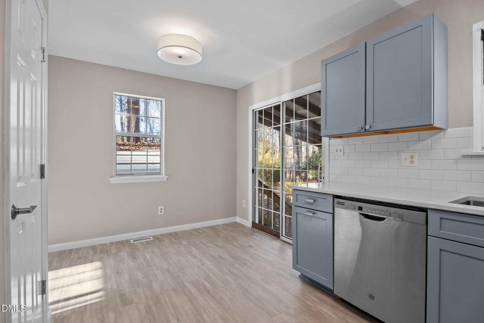 A kitchen with a wood floor and a window.