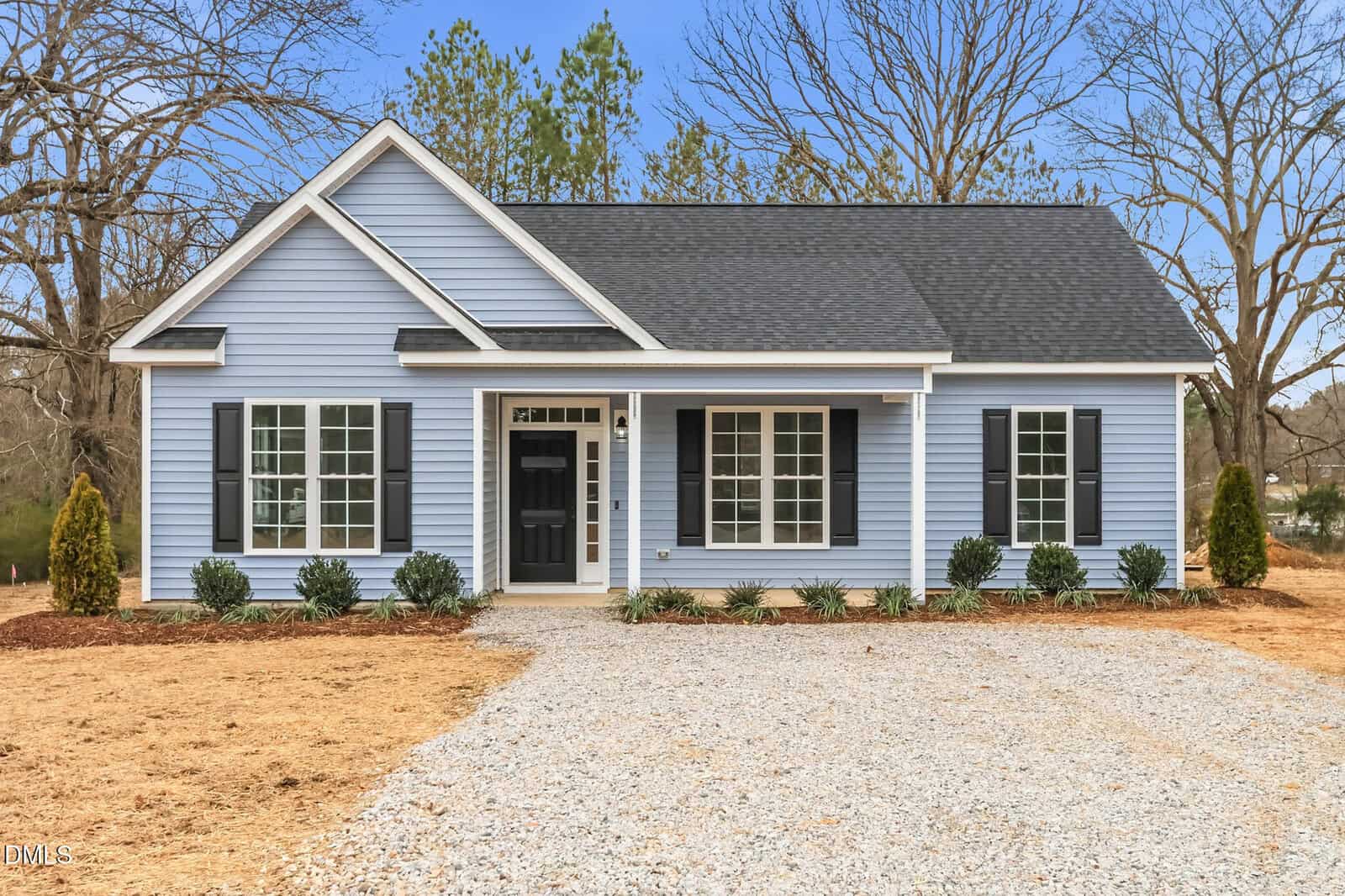 A house with gravel driveway and trees with Little White House in the background.