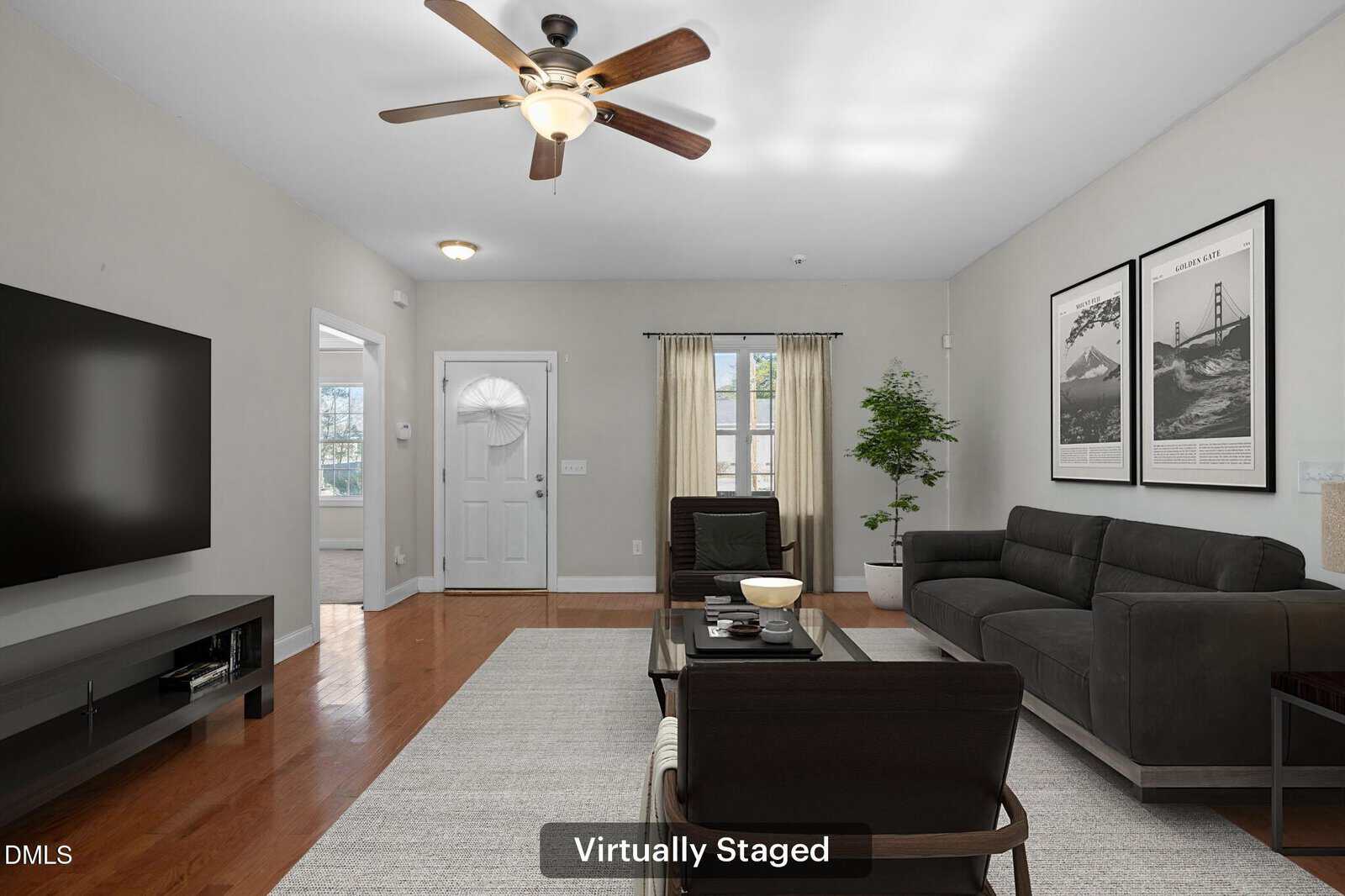 A living room with a couch and a fan.