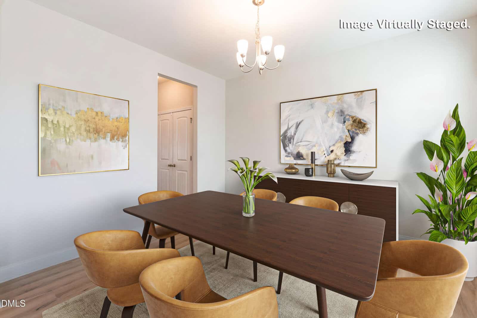 A modern dining room with a dark wooden table, six tan chairs, a sideboard with decor, abstract art on white walls, a potted plant, wood flooring, and a small chandelier overhead. Text reads "Image Virtually Staged.