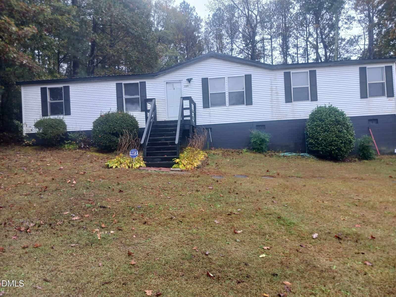 A house with a lawn and bushes.