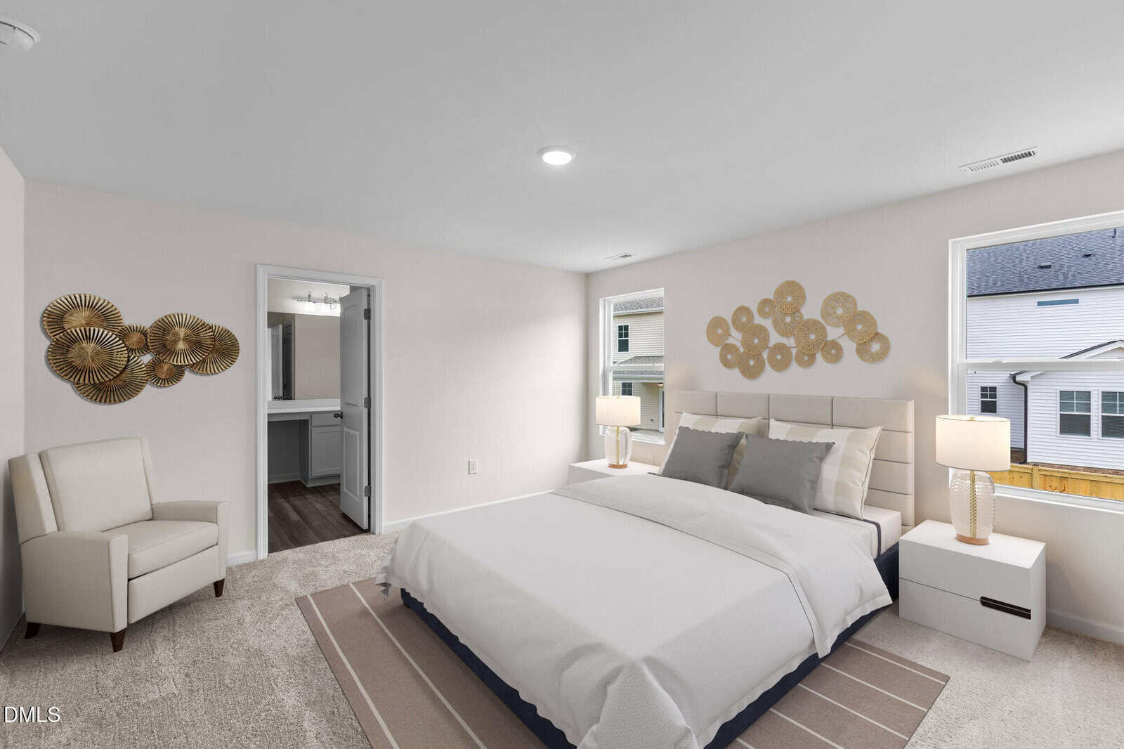 Modern bedroom with a large bed, two nightstands with lamps, an armchair, beige carpet, wall art, and two windows letting in natural light. An open doorway leads to a bathroom.