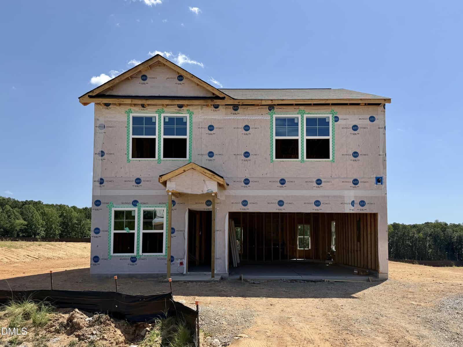A two-story house under construction at 345 Buckthorn Drive in Youngsville, covered in house wrap with exposed framing, windows installed, and an unfinished garage, set on a dirt lot with trees in the background.