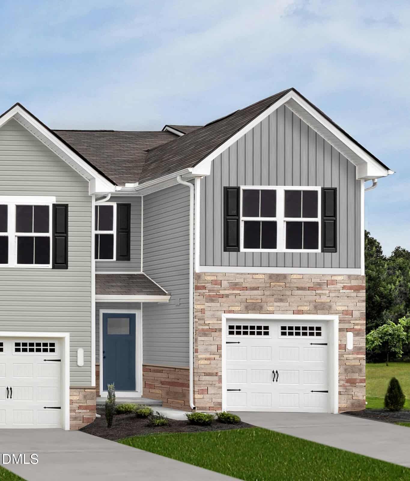 Charming two-story townhouse at 1164 Robins Nest Drive in Youngsville, featuring gray siding, stone accents, black shutters, two white garage doors, and a striking blue front door. A small lawn with plants and shrubs welcomes you in front, framed by mature trees and a cloudy sky in the background.