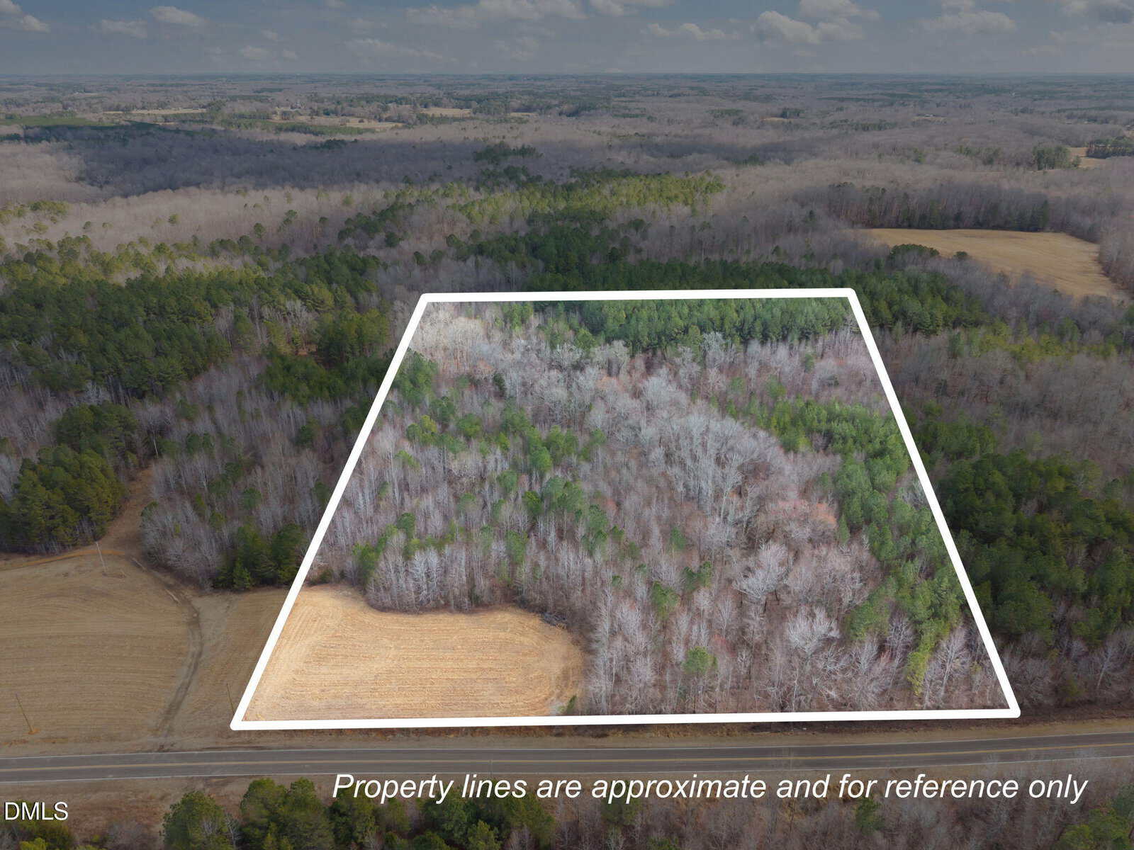 Aerial view of a wooded area in winter with property lines outlined in white for reference, highlighting Lot 2 Collie Jones Road in Rougemont. Surrounding areas feature trees and open fields. Text at bottom notes that property lines are approximate and for reference only.