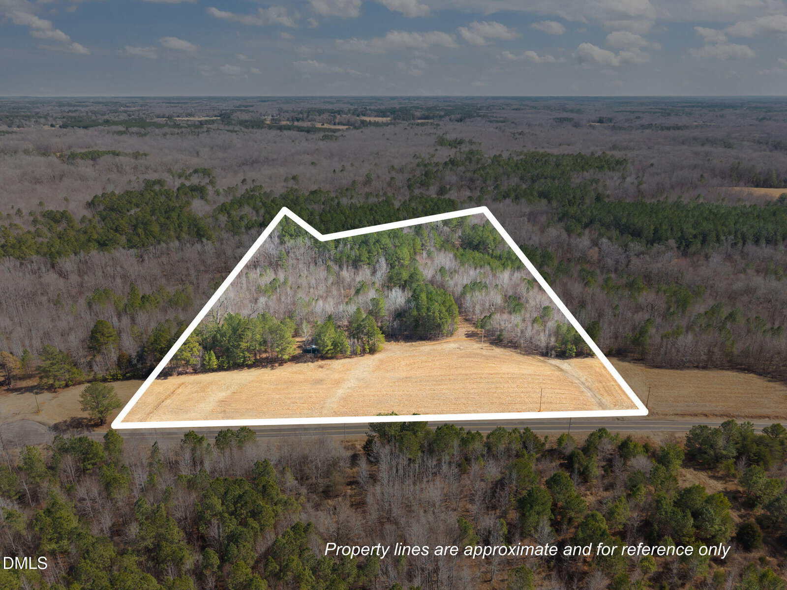 Aerial view of a wooded and grassy land parcel outlined in white along Lot 3 Collie Jones Road in Rougemont, with a road in front and surrounding forest. Text on image states property lines are approximate and for reference only.