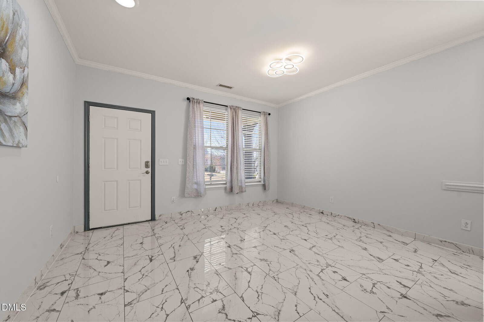 Unfurnished room with marble tile floor, light gray walls, a white entry door, and two large windows with sheer curtains. A ceiling light fixture is on, and daylight streams through the windows.
