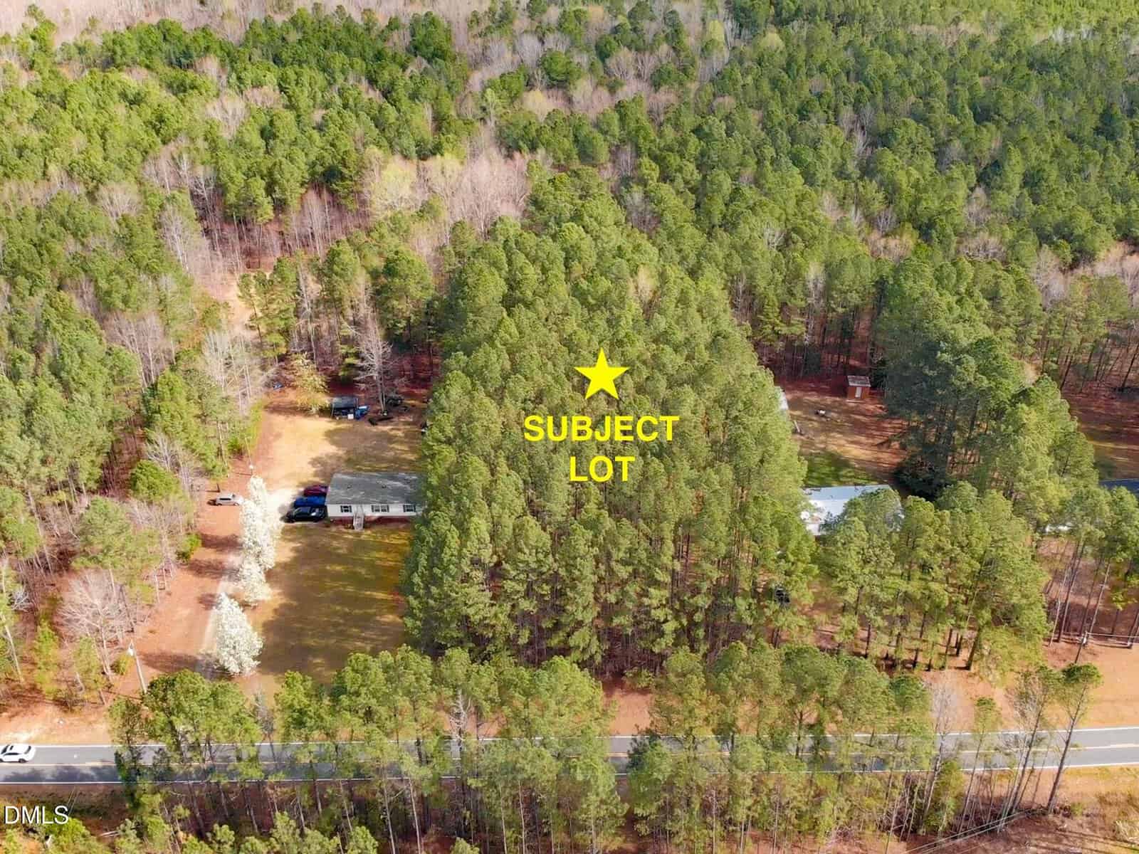 Aerial view of a wooded area near 00 Slick Williams Road in Macon, with a yellow star and “SUBJECT LOT” label marking a lot surrounded by trees, rural homes, and a road at the bottom edge of the image.