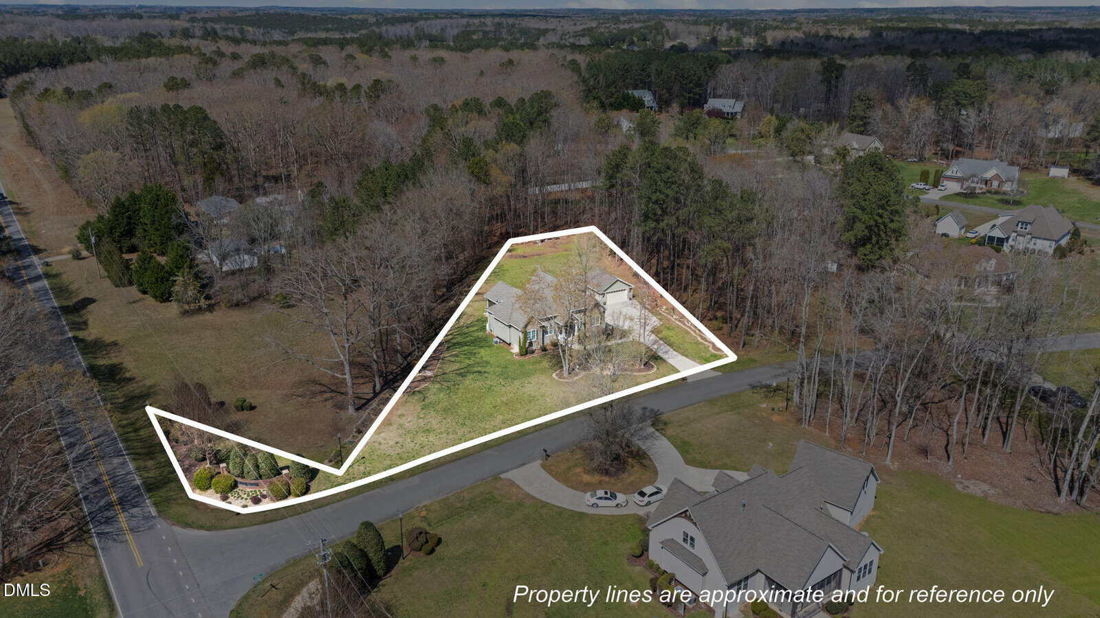Aerial view of a residential property with approximate boundary lines highlighted in white. The property includes a house, lawn, and surrounding trees, bordered by roads on two sides. Text notes lines are for reference only.