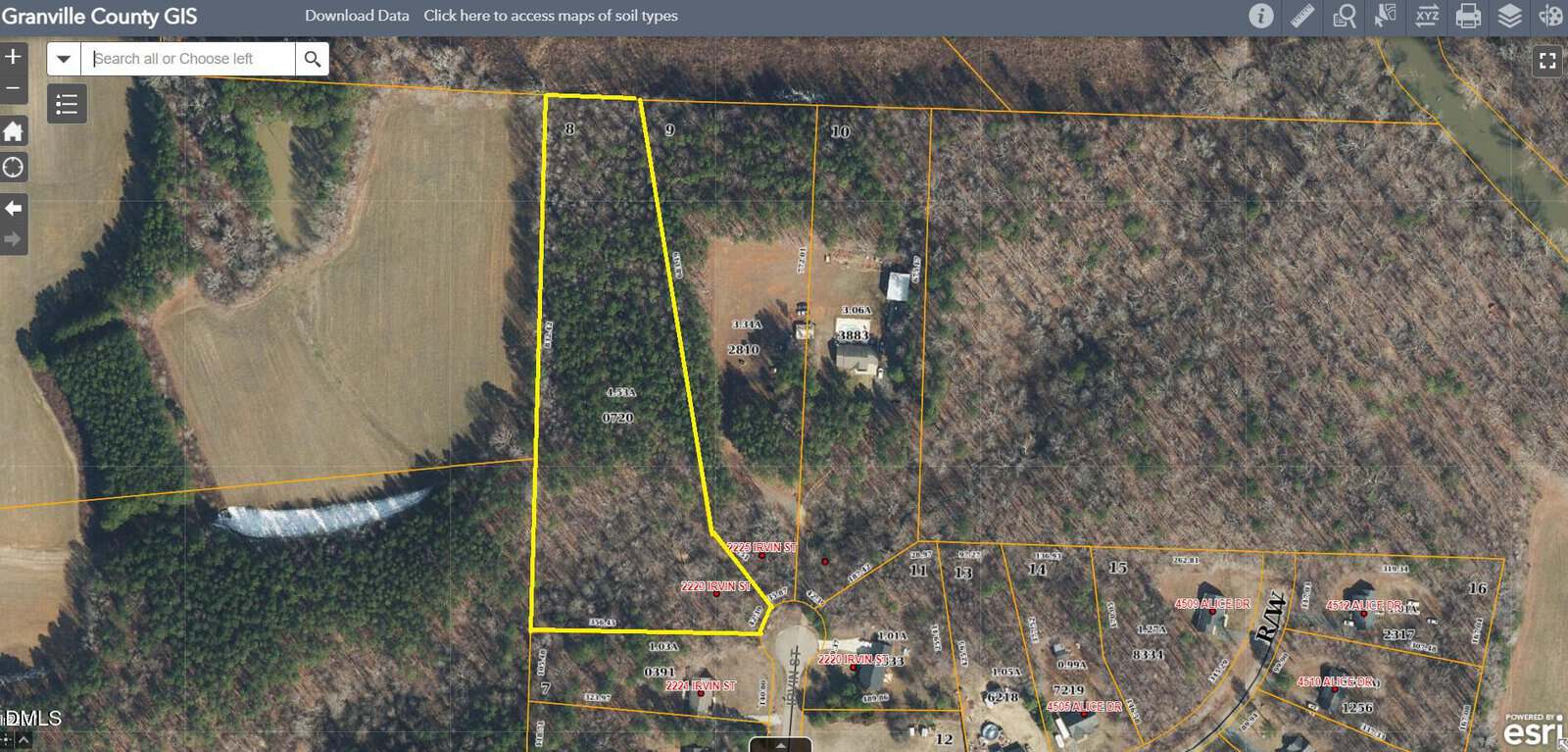 Aerial map view showing a wooded parcel of land outlined in yellow within Granville County GIS. The parcel is surrounded by forest, a few houses, and residential plots with labeled street addresses.