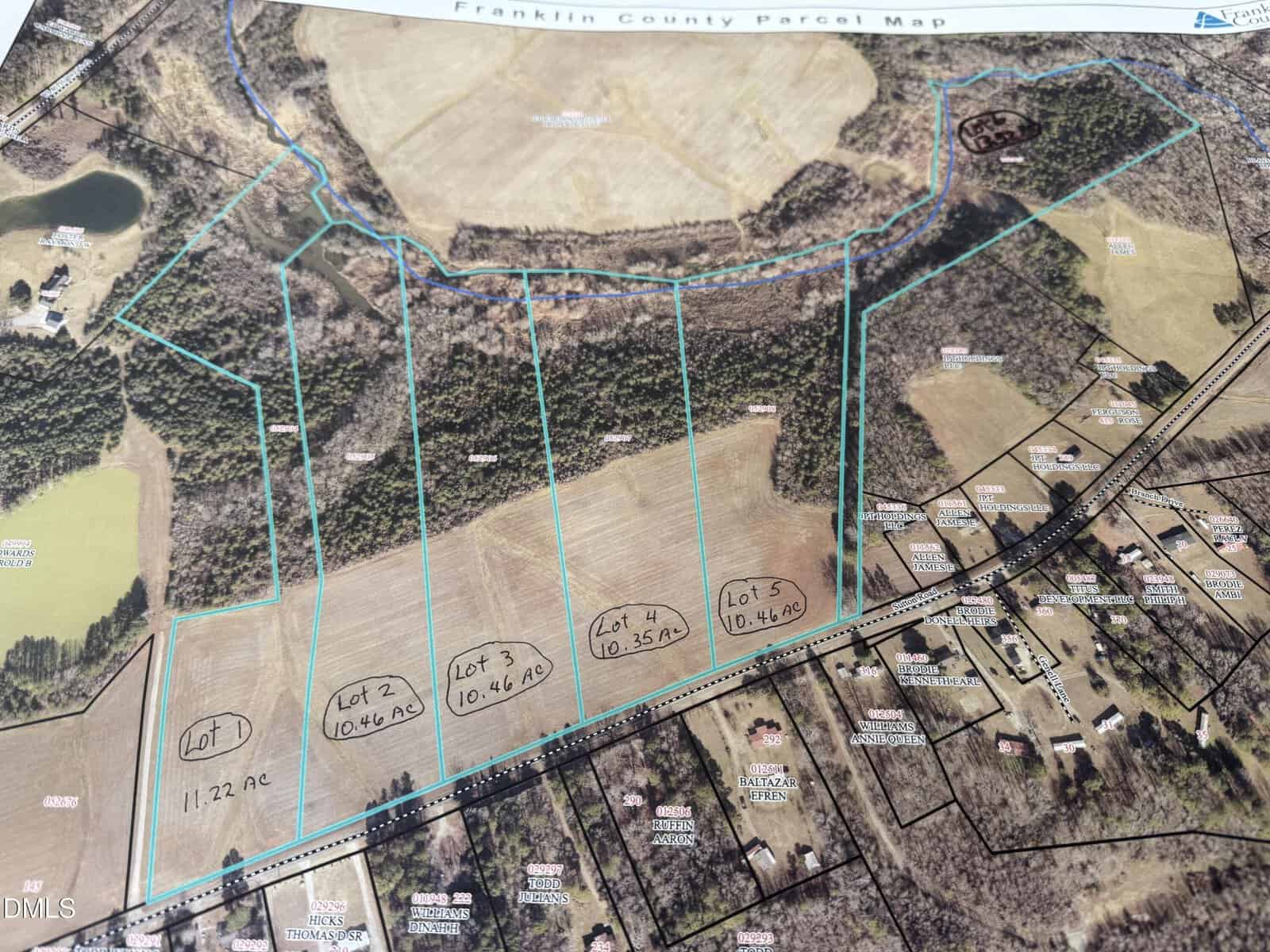 A map displays outlined land parcels labeled Lot 1 through Lot 5, each marked with acreage; surrounding areas include wooded sections, open fields, and nearby residential properties.
