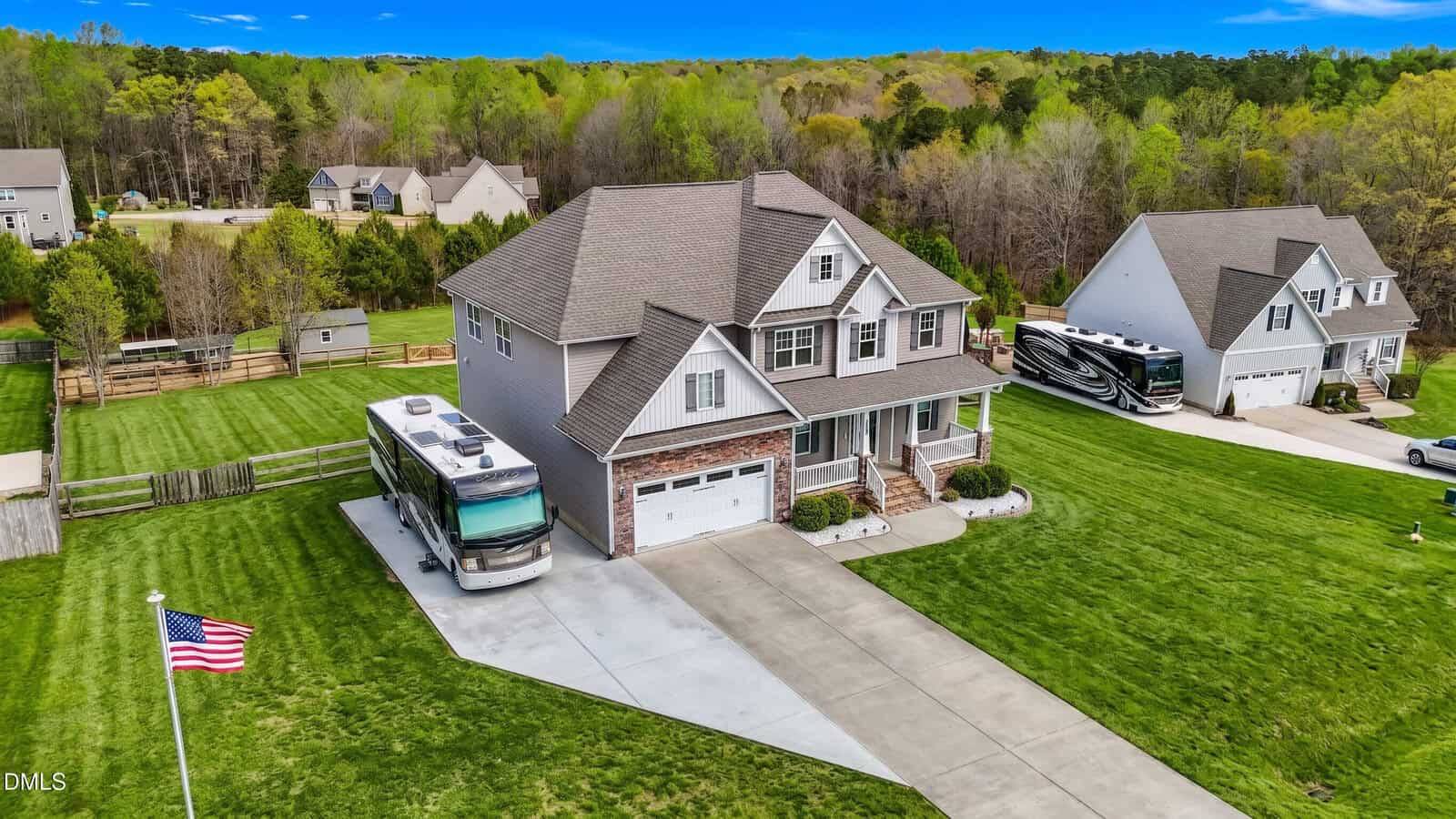 A two-story house at 1034 Butterfly Circle in Wake Forest features a large driveway, an American flag, and an RV parked beside it, all surrounded by green lawns and trees; neighboring houses are visible in the background.