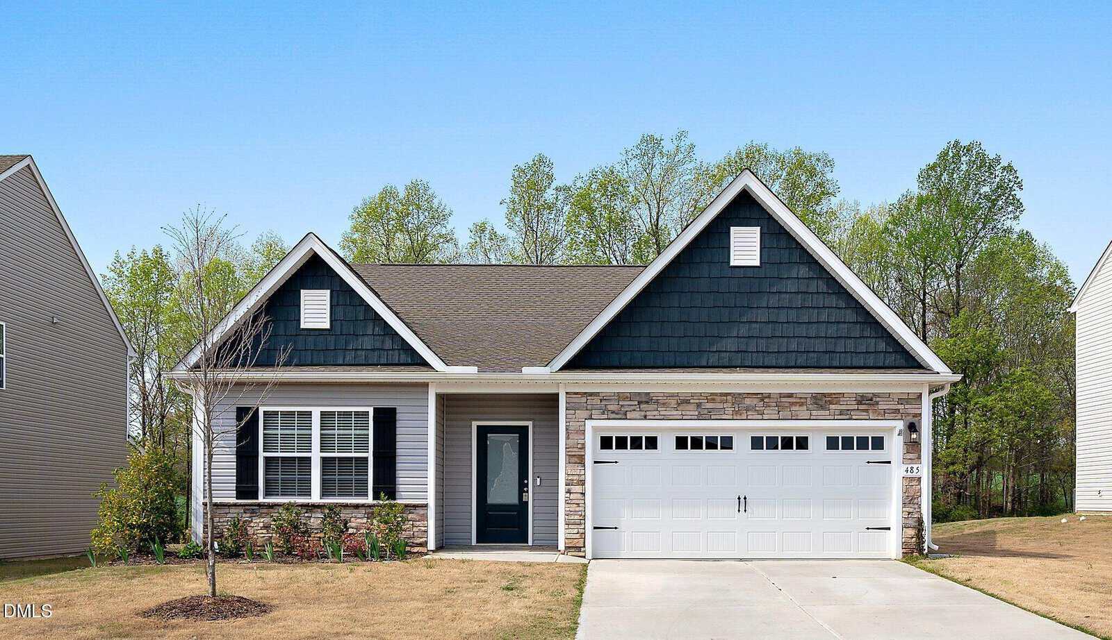 Single-story house at 485 Access Drive, Youngsville, featuring dark blue siding, stone accents, white trim, a double garage, small porch, and a simple front yard with young trees and sparse grass. Trees and clear sky in the background.