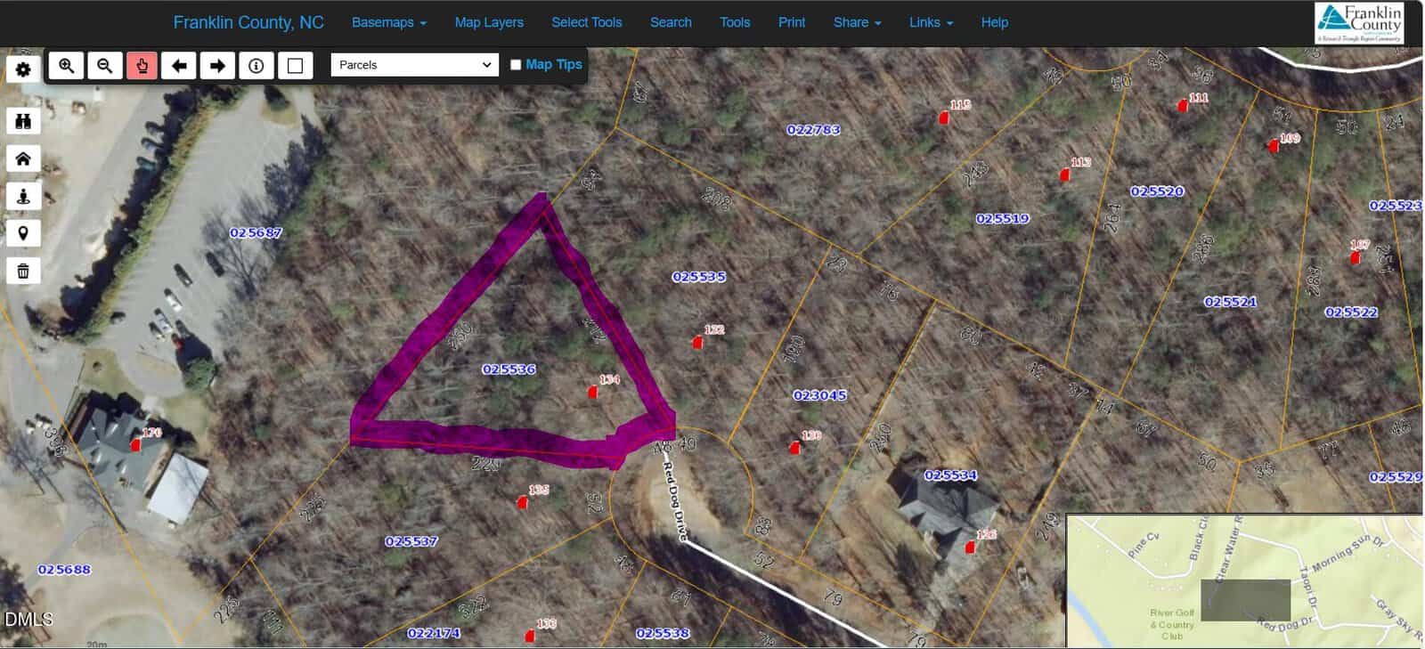 Aerial map showing Franklin County, NC parcels. A triangular parcel is outlined in purple, surrounded by wooded lots with parcel numbers and some structures. An inset map shows the county’s location.